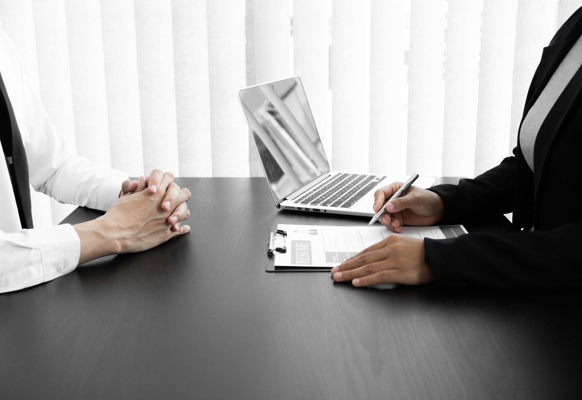 Interviewer Listening to Candidate While Reading his Resume